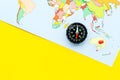 Travel direction and trip planning concept with compass and map of the world on yellow background top view mock up Royalty Free Stock Photo