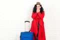 Travel dream. Girl can`t believe that won a trip. Stylish woman ready to travelling. Girl with suitcase over white wall, copy