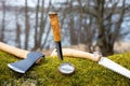 Travel equipment for a forest trip . Axe, knife, compass and saw on the moos