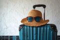 Travel essentials retro hat, sunglasses, and luggage on isolated space