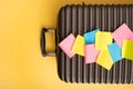 Travel flat lay composition of suitcase with colorful blank note on yellow background. Prepare trip concept or business Royalty Free Stock Photo