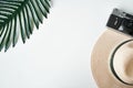 Travel flat lay. Tropical leaves ,camera and straw hat on white background