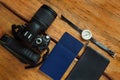 Travel flatlay on brown wooden background with camera, international passports, wallet and compass