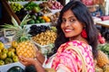 Travel girl seller in street market and a buyer in a fruit shop in india delhi.smiling business woman indonesian in Royalty Free Stock Photo