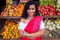 Travel girl seller in street market and a buyer in a fruit shop in india Royalty Free Stock Photo