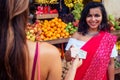 Travel girl seller in street market and a buyer in a fruit shop in india Royalty Free Stock Photo