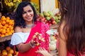 Travel girl seller in street market and a buyer in a fruit shop in india Royalty Free Stock Photo