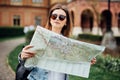 Travel guide, tourism in Europe, woman tourist in sunglasses with map on the street Royalty Free Stock Photo