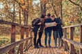 Group of young friends hiking in autumn colorful forest, looking at map and planning hike. Royalty Free Stock Photo