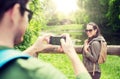 Couple with backpacks taking picture by smartphone Royalty Free Stock Photo