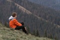 Travel hiking journey outdoor. Alone brown hair boy watch over valley and sits on the hillside