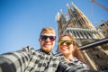 Travel, holidays and people concept - Happy couple taking selfie photo in front of the Sagrada Familia in Barcelona