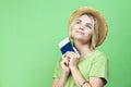 Travel Ideas. Dreaming Winsome Llovely Smiling Young Girl in Straw Hat Holding Passport with Tickets isolated Over Trendy Green
