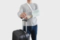 Travel insurance concepts. a man with hand injured wearing splint, broken arm, showing empty blank card, with baggage