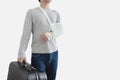 Travel insurance concepts. Young man with hand injured wearing splint, broken arm, holding black baggage, Royalty Free Stock Photo