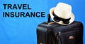 Travel insurance-provides financial well-being in life situations. Inscription text on the background of Luggage: suitcase, hat,