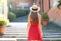 Travel in Italy. Back view of tourist girl climbs the stairs in Bellagio, Italy. Young traveler woman on her summer vacations on