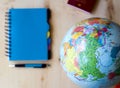 Travel items, blue notepad, pen, globe on wooden background Royalty Free Stock Photo