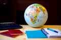 Travel items, blue notepad, pen, pc, globe on wooden background Royalty Free Stock Photo