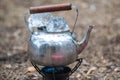 Travel kettle with ice on the primus fire.