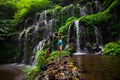 Excited Caucasian woman raising arms in front of waterfall. View from back. Travel concept. Banyu Wana Amertha waterfall Wanagiri Royalty Free Stock Photo