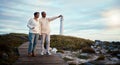 Travel, love and elderly couple pointing on boardwalk at beach, calm at a lighthouse against sunset sky. Senior, man Royalty Free Stock Photo