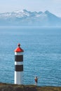 Travel in Norway tourist walking at Lyngstuva lighthouse enjoying ocean view