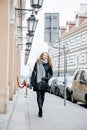 Travel the old city. A young woman travels. Market Square in Warsaw. Curly girl walks through the streets of the city.