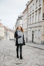 Travel the old city. A young woman travels. Market Square in Warsaw. Curly girl walks through the streets of the city.
