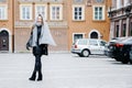 Travel the old city. A young woman travels. Market Square in Warsaw. Curly girl walks through the streets of the city.