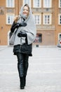 Travel the old city. A young woman travels. Market Square in Warsaw. Curly girl walks through the streets of the city.