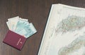 Travel passport with bitcoin sign, a bundle of Malaysian money and a map of Malaysia on the mahogany table Royalty Free Stock Photo