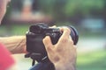 Travel photographer with camera in hand make photo outdoor Royalty Free Stock Photo