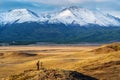 Travel photographer on a hilltop in the Kurai steppe, view of the North Chuysky ridge