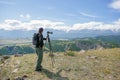 Travel photographer man taking nature photo or video of mountain landscape.