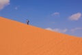 Travel photography wallpaper pattern scenic view of tourist man go forward and up on dune sand hill in Wadi Rum desert landscape Royalty Free Stock Photo