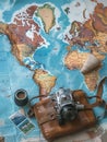 Travel memories captured on a vintage camera atop a world map with postcards and travel essentials. Generative AI