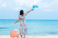 Travel Plan. women traveler holding orange luggage walking on the beach. Traveler and Tourism planning trips summer vacations