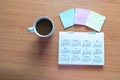 Travel Planning on Calendar and use post-it for note with a cup of coffee on a wooden table Royalty Free Stock Photo