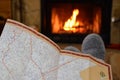 Travel planning, map, relaxation with a fire in the fireplace Royalty Free Stock Photo