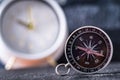 Travel planning navigation concept. Classic magnetic detail of compass on light blue with watch show time in backround. Royalty Free Stock Photo