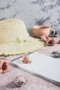 Travel planning notebook, hat, seashells and cup of coffee on table vertical view Royalty Free Stock Photo