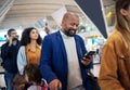 Travel, queue and phone with black man in airport for flight, vacation and immigration. Happy, communication and Royalty Free Stock Photo