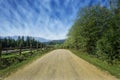 Travel road on the farm with green grass and blue sky with clouds on the farm in beautiful summer sunny day. Clean, idyllic, land Royalty Free Stock Photo