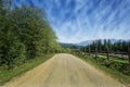 Travel road on the field with green grass and blue sky with clouds on the farm in beautiful summer sunny day. Clean, idyllic, land Royalty Free Stock Photo