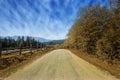 Travel road on the field with yellow autumn grass and blue sky with clouds on the farm in beautiful summer sunny day. Clean, Royalty Free Stock Photo