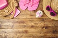 Travel saving budget concept with piggy bank, hat and flip flops on wooden table. Top view from above