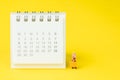 Travel schedule or reminder calendar concept, miniature people young lady with luggages or baggage beside small clean calendar on Royalty Free Stock Photo