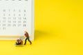 Travel schedule or reminder calendar concept, miniature people young man with luggages or baggage trolley with small clean Royalty Free Stock Photo
