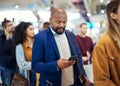 Travel, search and phone with black man in airport for flight, vacation and immigration. Queue, communication and Royalty Free Stock Photo